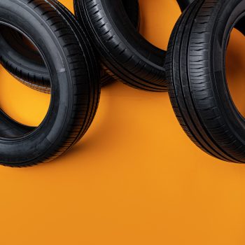 Car tires isolated on yellow background, close up photo